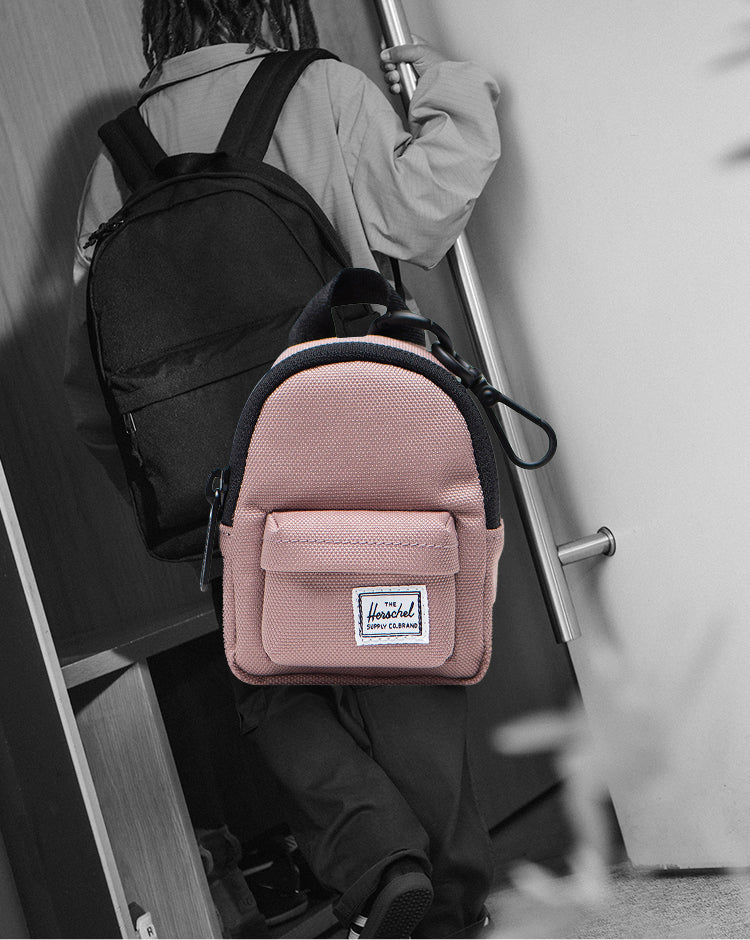 Herschel Supply Co. Classic Backpack Bag Charm in Ash Rose pink, styled on a mobile screen perspective.